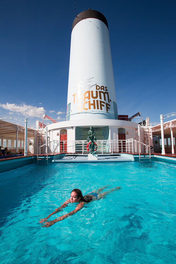 Junge Frau schwimmt in Pool von Kreuzfahrtschiff MS Deutschland (Reederei Peter Deilmann), nahe Sevilla, Andalusien, Spanien, Europa