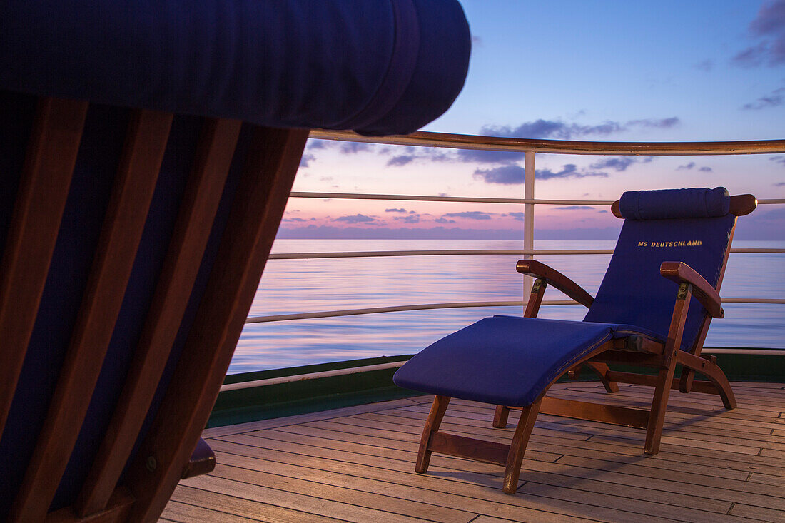 Liegestuhl an Deck von Kreuzfahrtschiff MS Deutschland (Reederei Peter Deilmann) in der Abenddämmerung, Mittelmeer, nahe Italien, Europa
