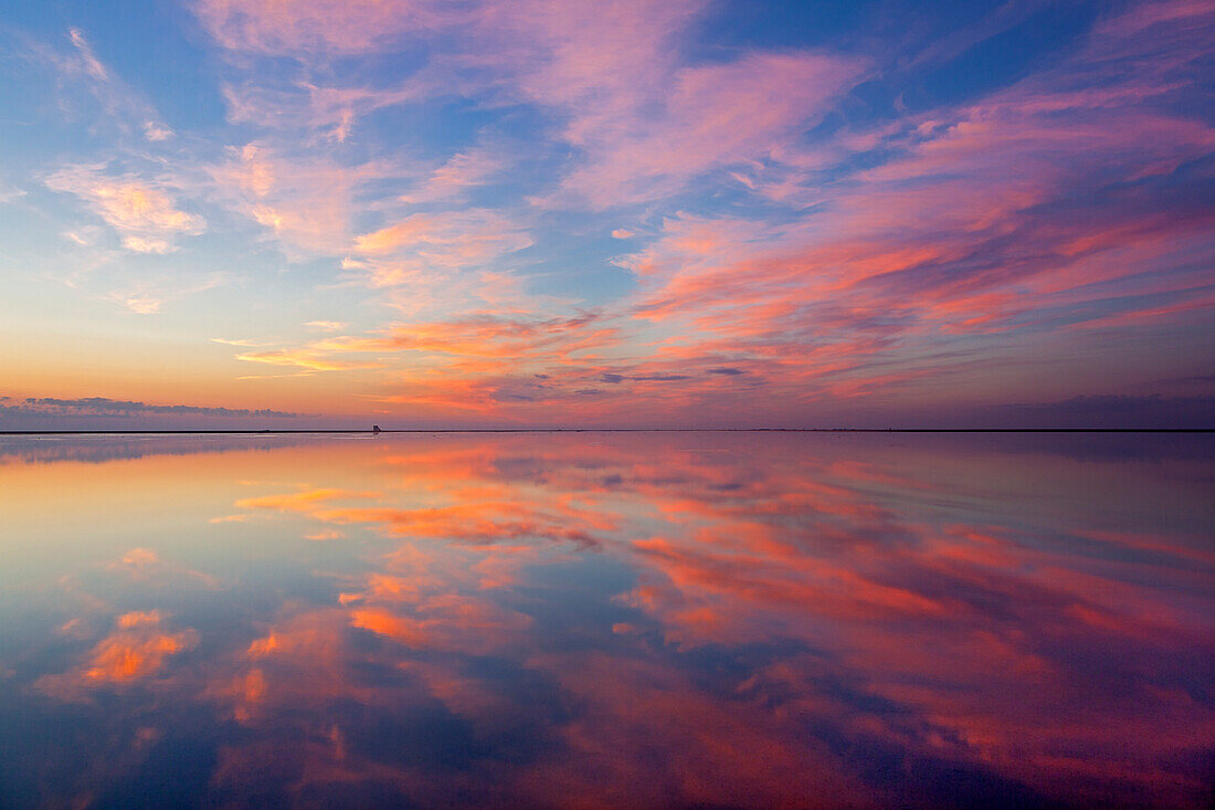 Evening clouds reflecting in the flats near Westerhever lighthouse, Eiderstedt peninsula, Schleswig-Holstein, Germany