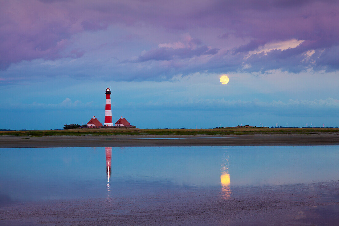 Lighthouse, thunder clouds and moon reflecting in the water, Westerhever lighthouse, Eiderstedt peninsula, Schleswig-Holstein, Germany
