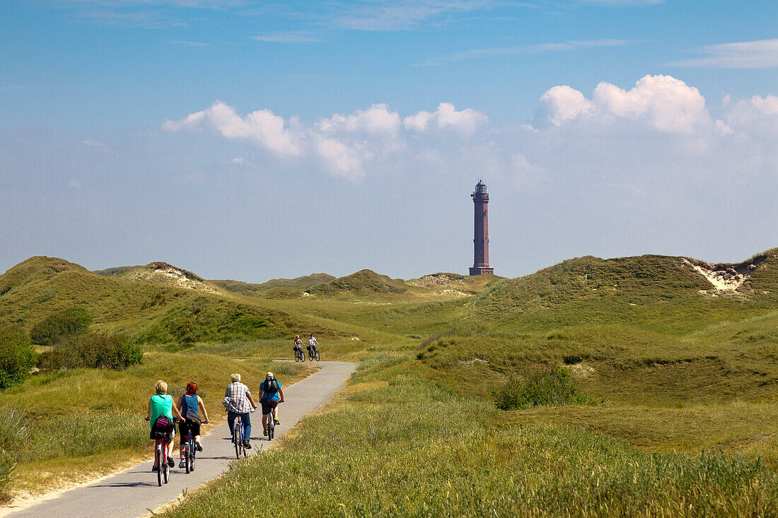 Fahrradfahrer am Weg zum Leuchtturm, Insel Norderney, Ostfriesland, Niedersachsen, Deutschland