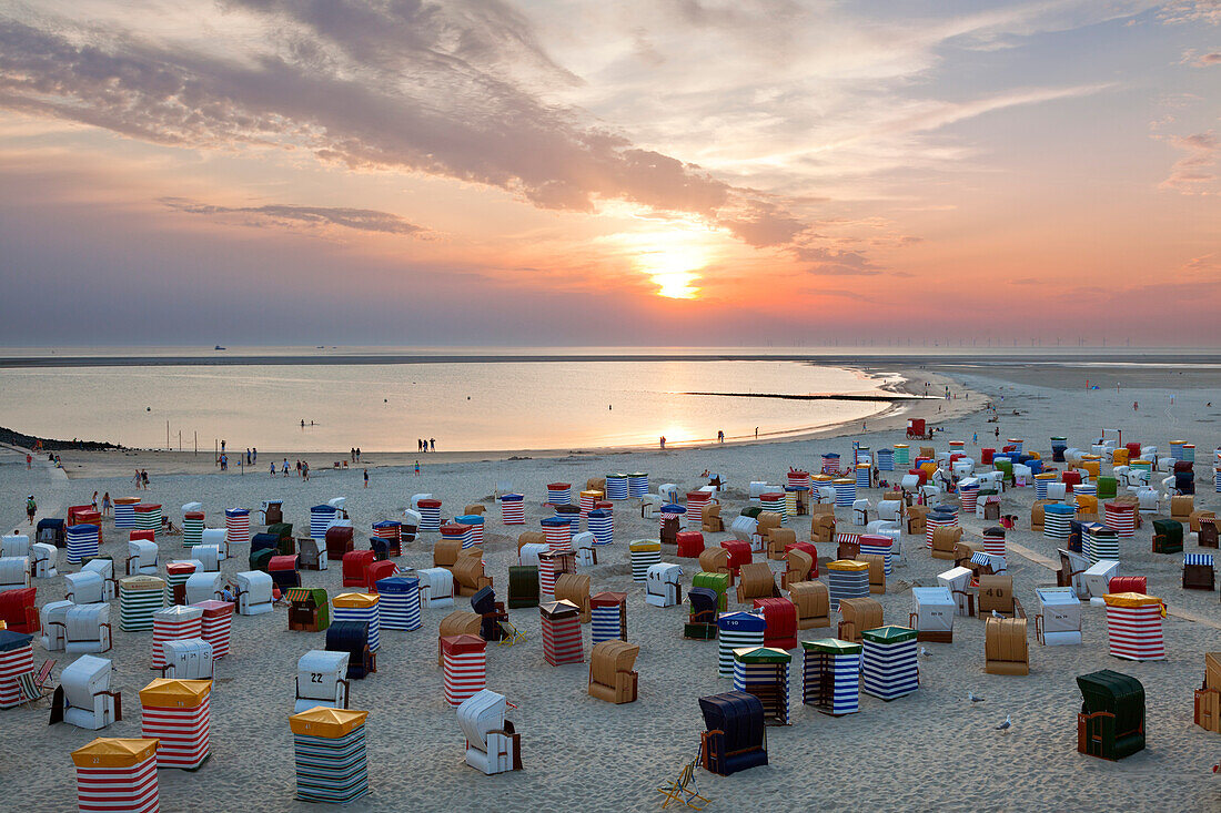 Menschen am Strand betrachten den Sonnenuntergang, Insel Borkum, Ostfriesland, Niedersachsen, Deutschland