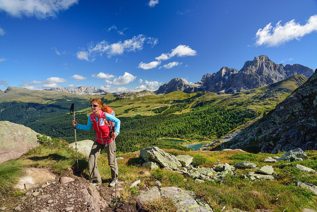 Woman walking on path high above lake Colbricon with Pala range in background, Trans-Lagorai, Lagorai range, Dolomites, UNESCO World Heritage Site Dolomites, Trentino, Italy