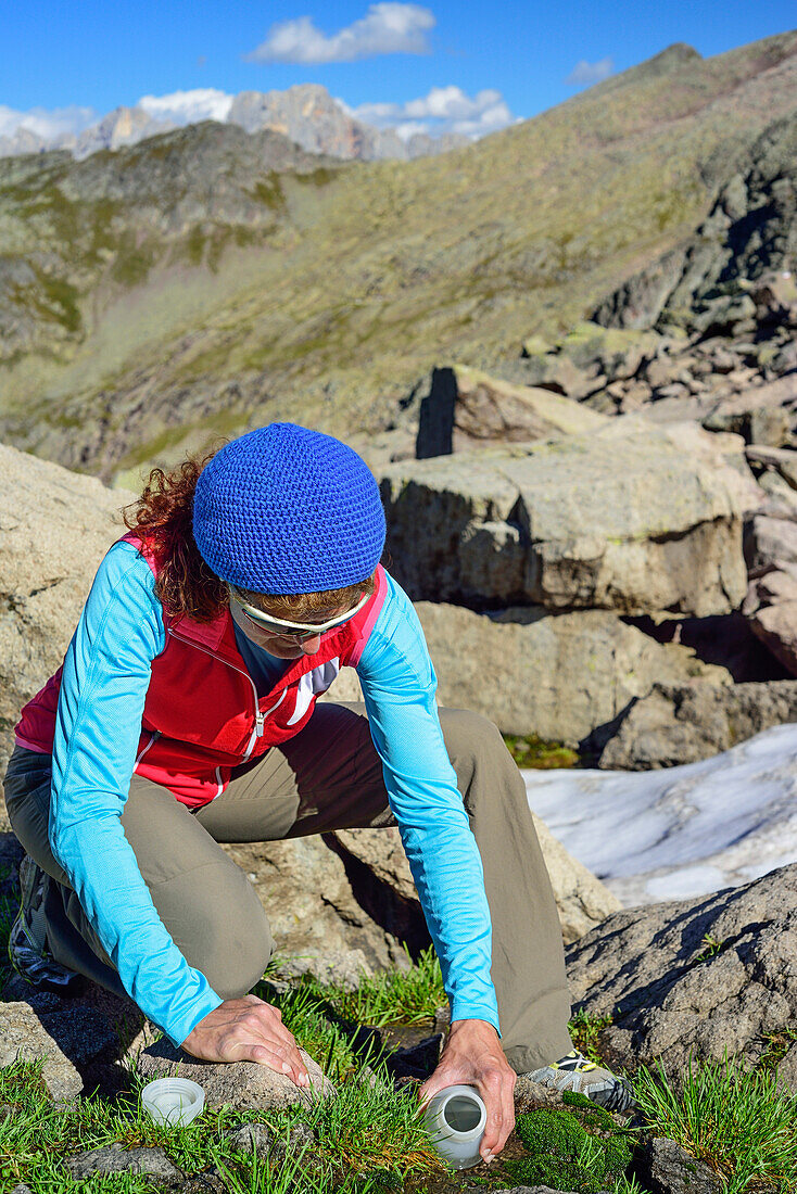 Woman scooping water from stream, Trans-Lagorai, Lagorai range, Dolomites, UNESCO World Heritage Site Dolomites, Trentino, Italy