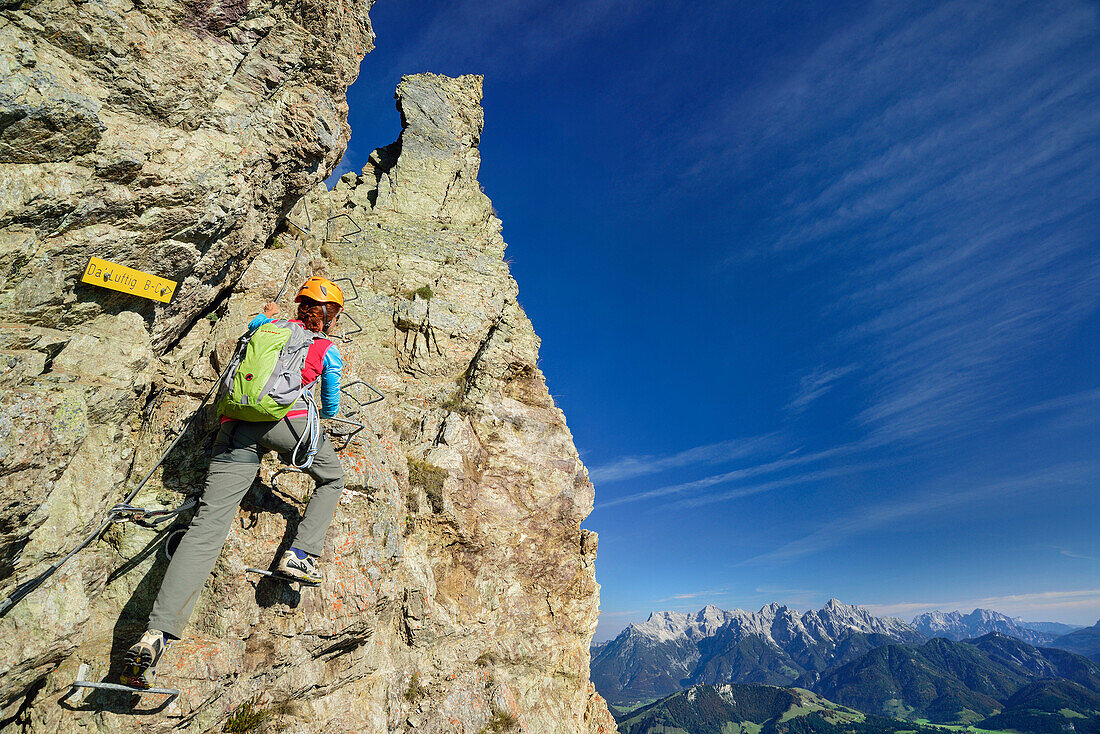 Frau steigt über Klettersteig auf, Loferer Steinberge im Hintergrund, Klettersteig Henne, Henne, Kitzbüheler Alpen, Tirol, Österreich