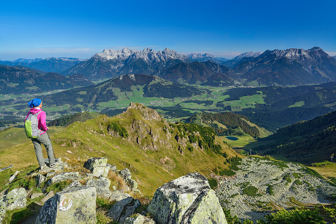 Frau steigt über Bergrücken auf, Loferer Steinberge im Hintergrund, Klettersteig Henne, Henne, Kitzbüheler Alpen, Tirol, Österreich