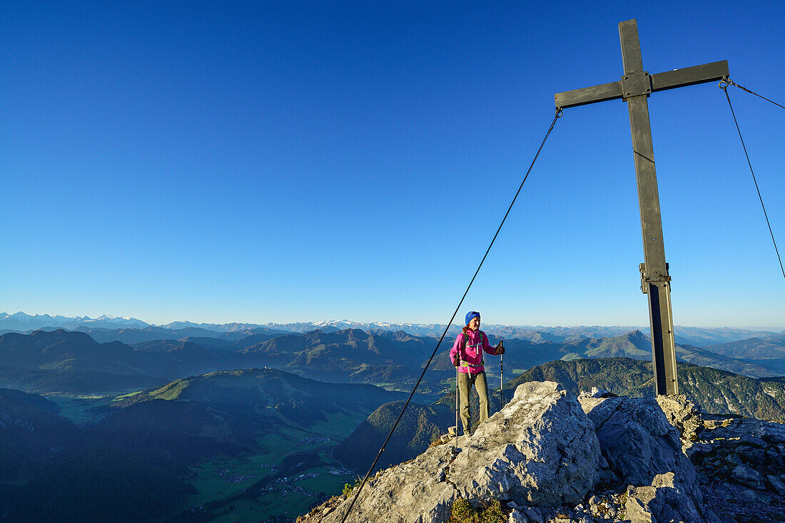 Woman reaching the summit cross Heimkehrerkreuz, beneath summit of Ulrichshorn while hiking, Nurracher Hoehenweg, Ulrichshorn, Loferer Steinberge range, Tyrol, Austria