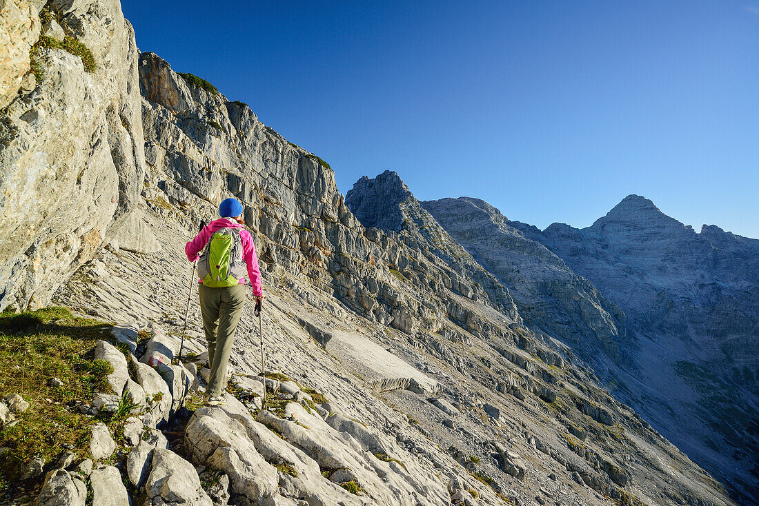 Woman hiking towards Rothorn and Mitterhorn, Nurracher Hoehenweg, Ulrichshorn, Loferer Steinberge range, Tyrol, Austria