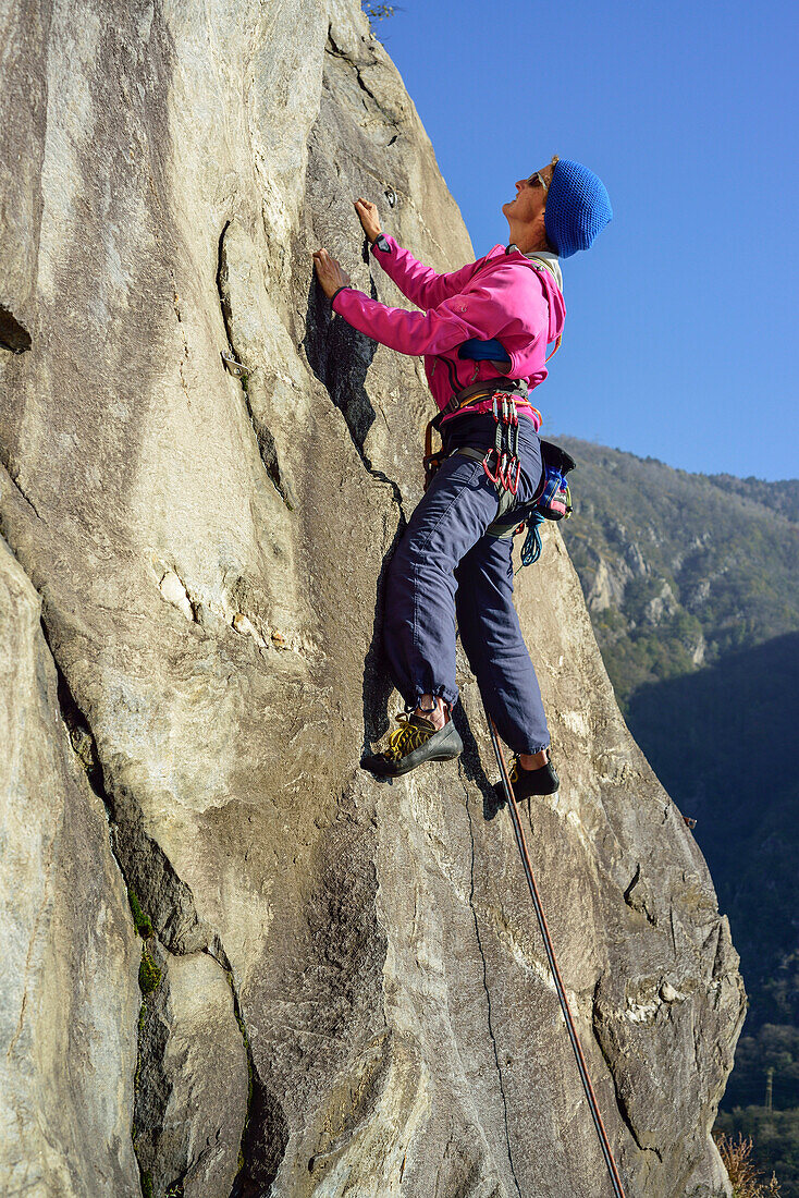 Frau klettert über Gneisfelsen, Placca di Tegna, Ponte Brolla, Tessin, Schweiz