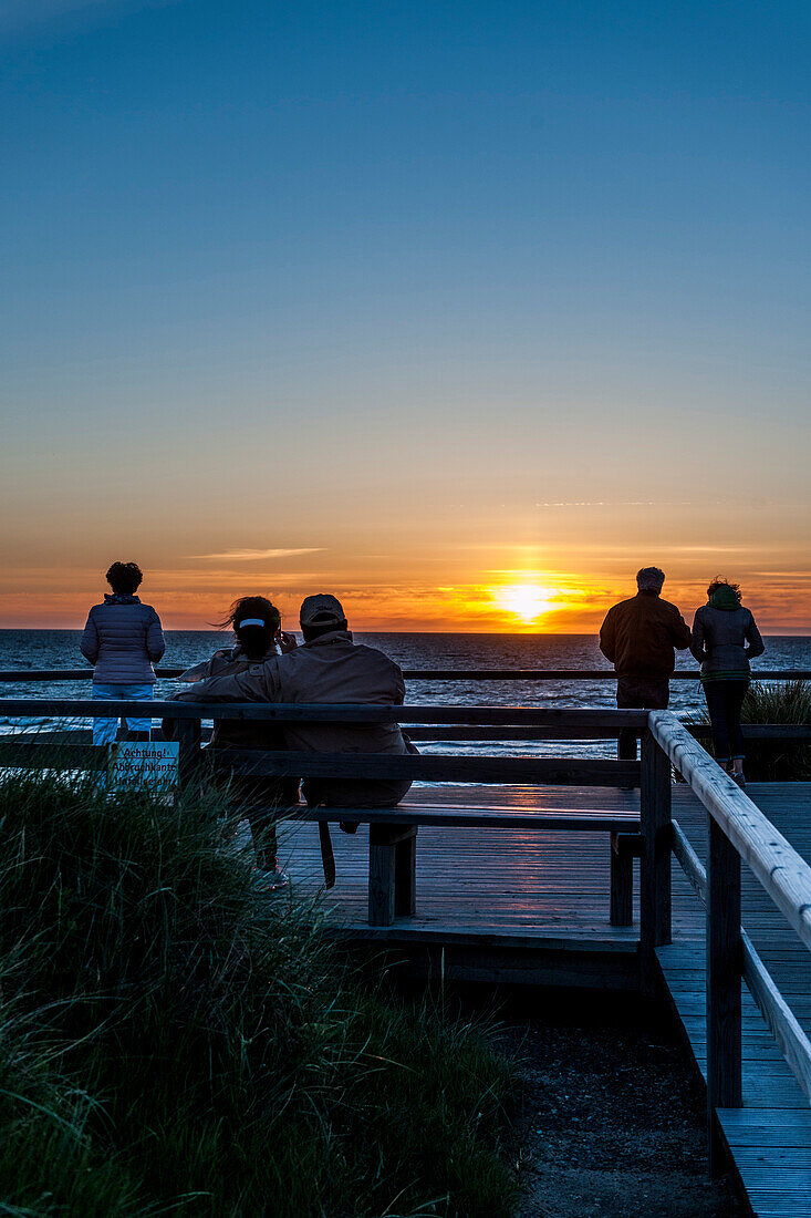 Personen betrachten Sonnenuntergang am Strand, Kampen, Sylt, Schleswig-Holstein, Deutschland