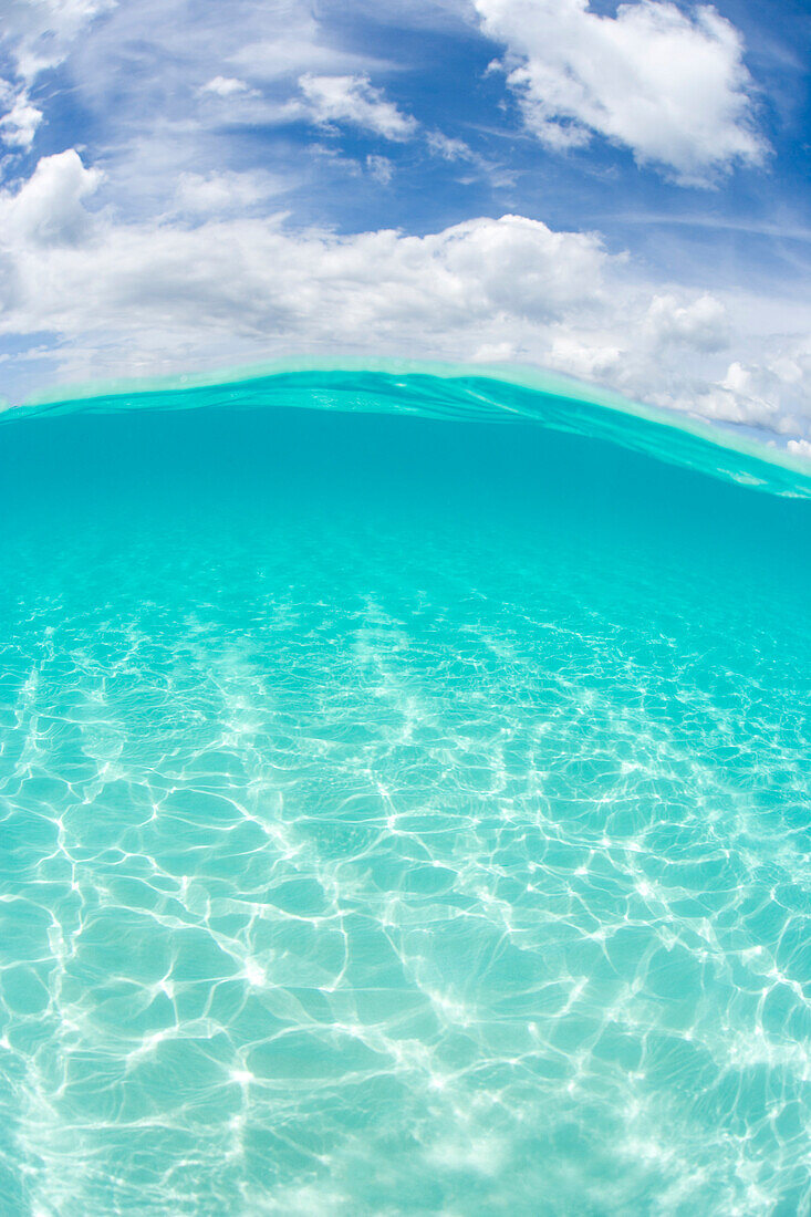 Over/Under View Of Shallow Ocean Water And Sky Above.