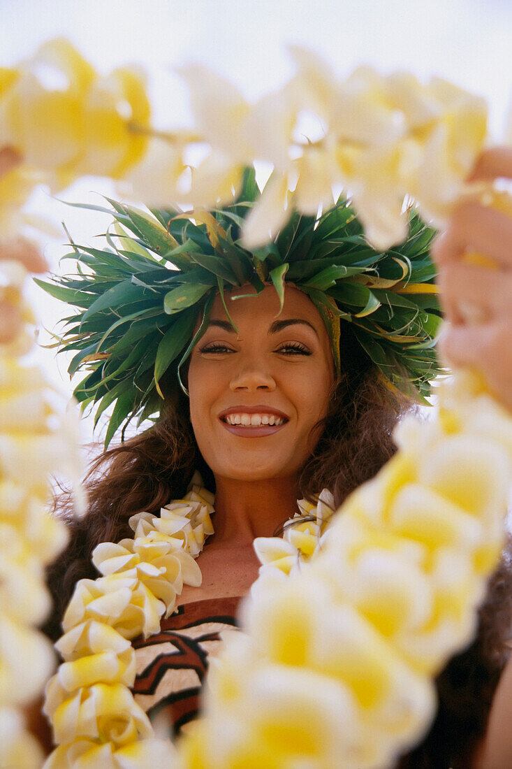 Close-Up Of Woman Holding Plumeria Lei Out In Front, About To Pass To C1489 Someone