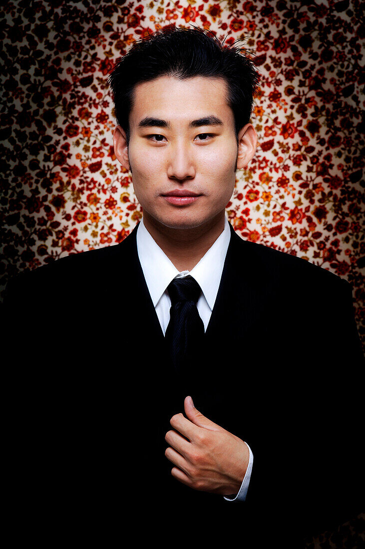 Man In Black Suit Against Floral Background