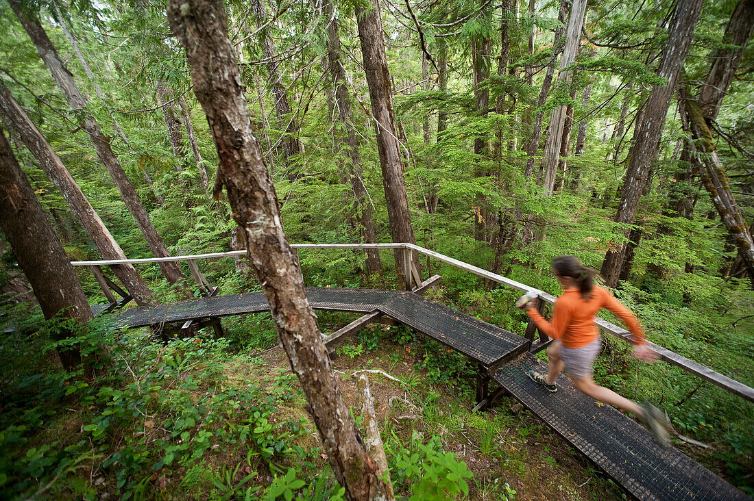 Woman Runs The Perseverance Trail In The Tongass National Forest Near Ketchikan, Alaska