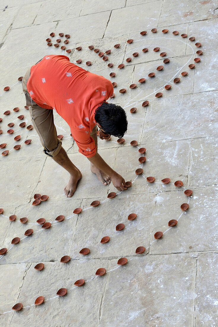 India, Uttar Pradesh, Varanasi, Dev Deepawali festival, Hindu devotee setting earthen lamps.