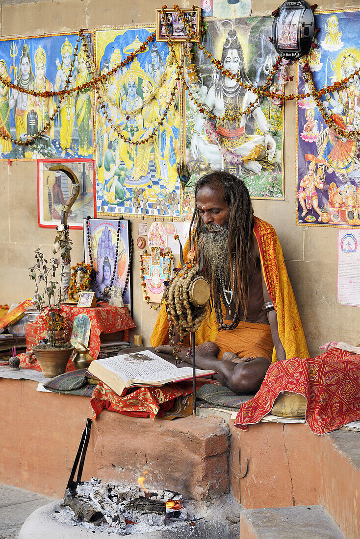 India, Uttar Pradesh, Varanasi, Shivaite sadhu reading sacred texts.