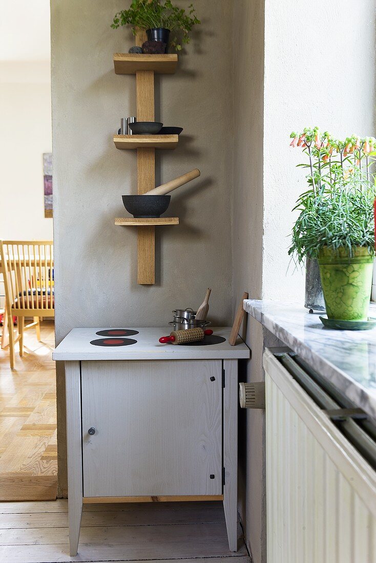 A children's kitchen and a homemade wooden shelf in the corner