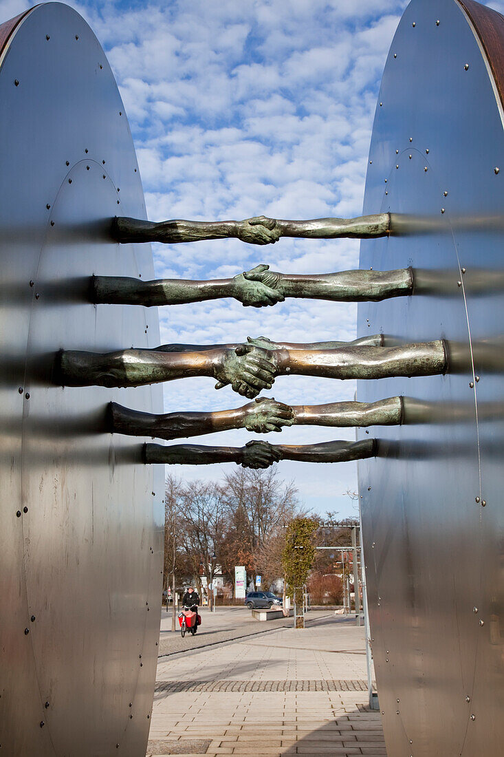 'Sculpture of arms outstretched into a handshake; Gilching, Bavaria, Germany'