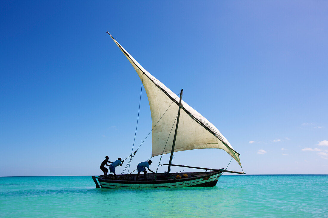 'Raising the sail on a boat on the Indian Ocean; Vamizi Island, Mozambique'