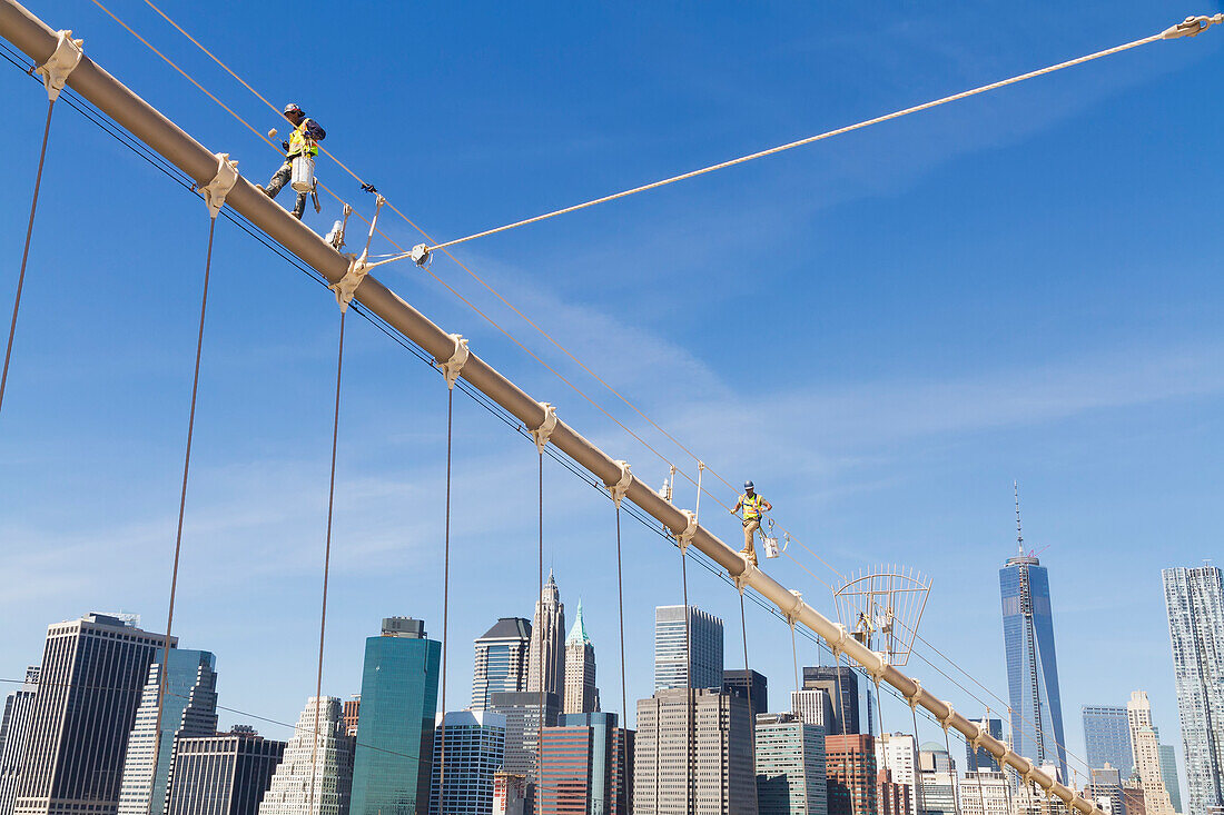 Men painting a suspension cable of the Brooklyn Bridge, New York City, New York, United States