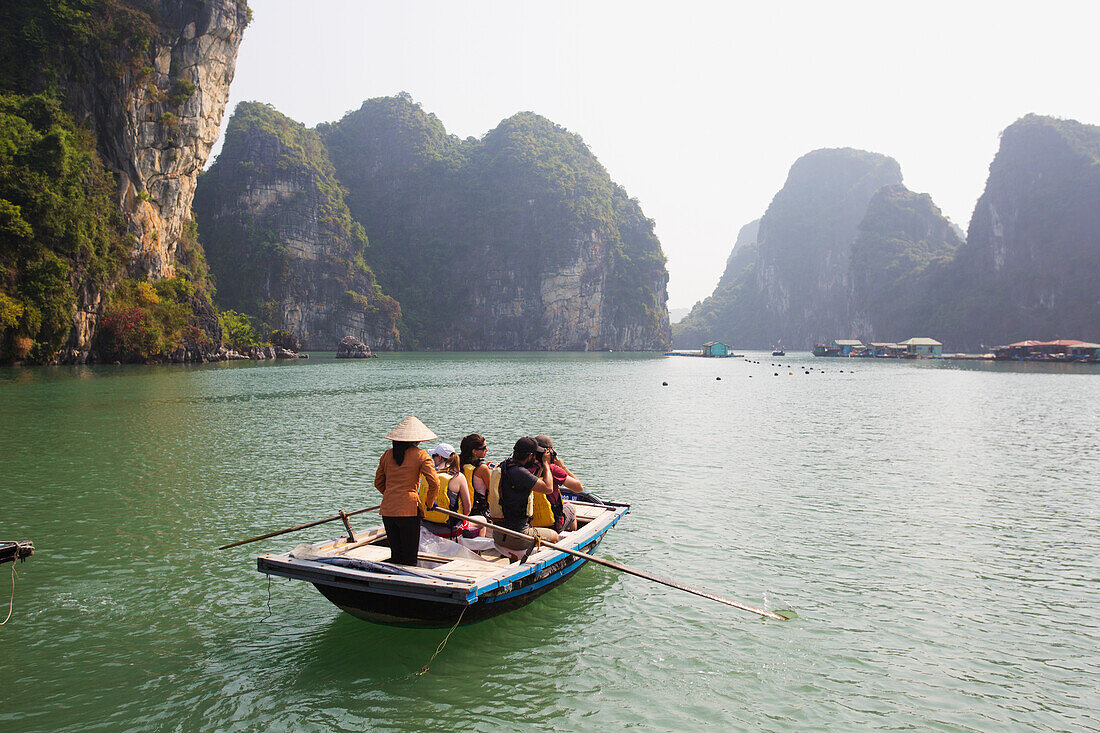 'Local woman rowing boat with tourists to the Vung Vieng Fishing Village in Bai Tu Long Bay, Halong Bay; Vietnam'