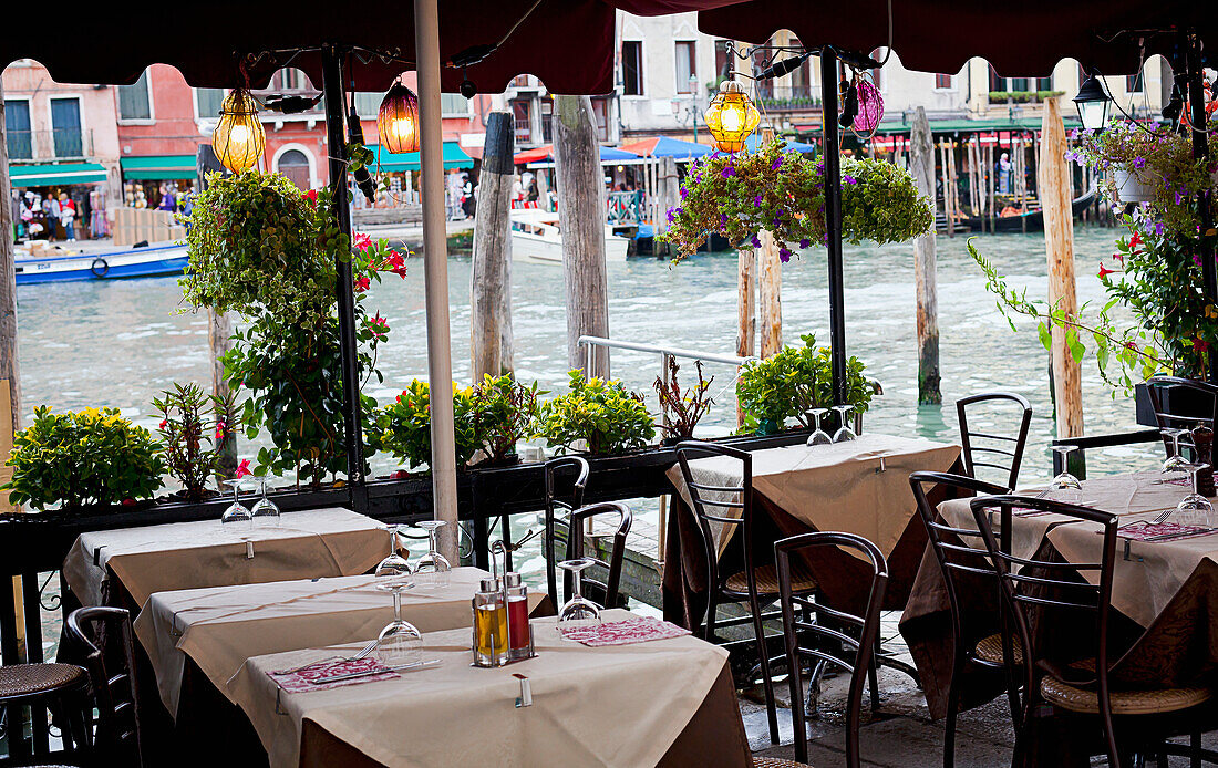 'An outdoor restaurant patio on a canal; Venice, Italy'
