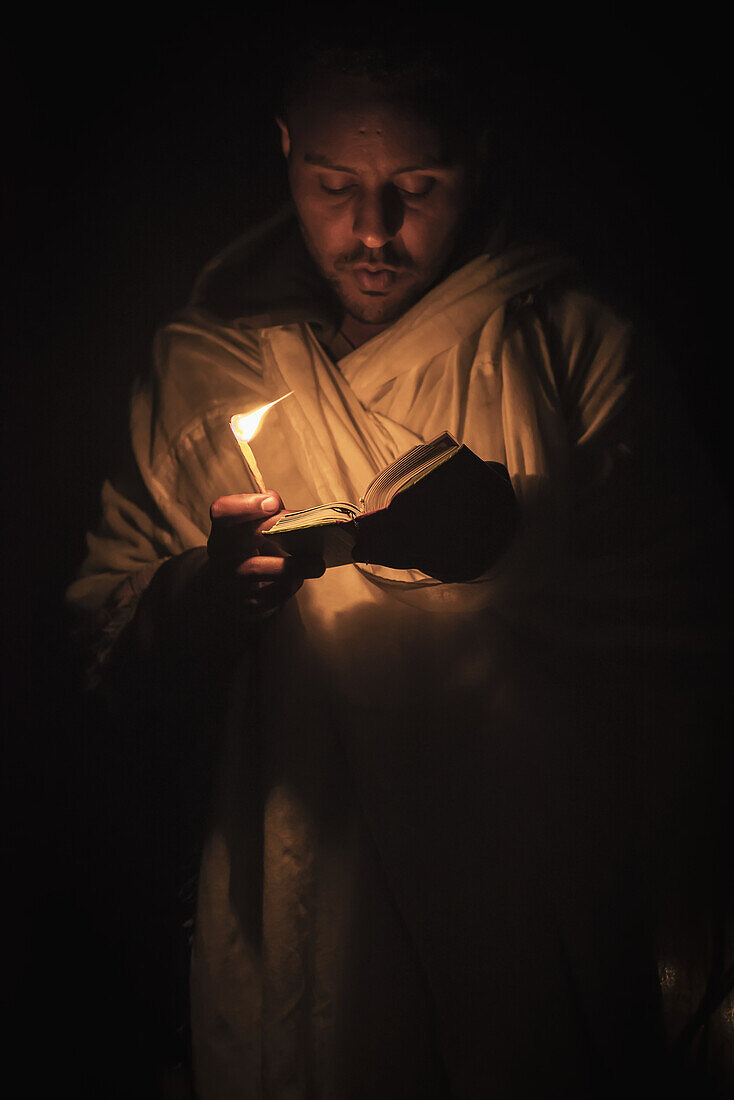 'Ethiopian pilgrim with Bible and candle; Lalibela, Ethiopia'
