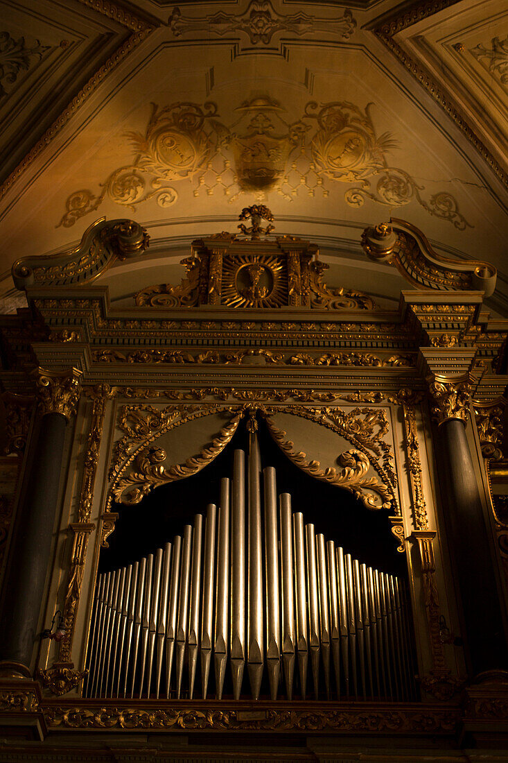Old organ pipes dramatically lit in a church in Italy.