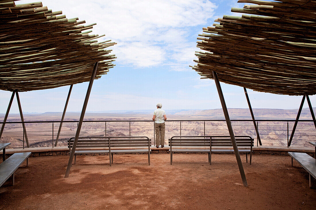 An older woman takes in the view from the rim of Namibia's Fish River Canyon.