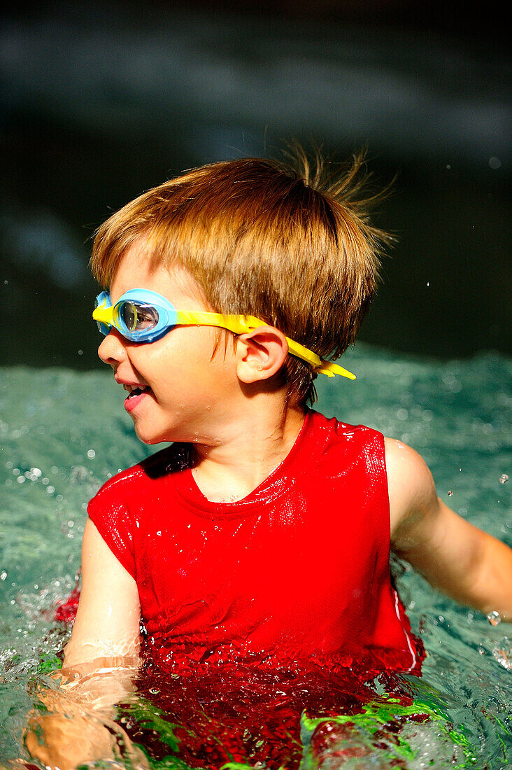 A  young boy playing in a swimming pool.