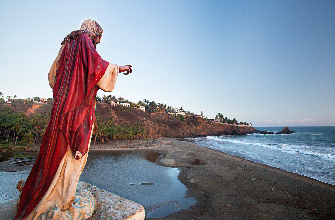 Statue of Jesus overlooks the small town Caleta De Campos in Mexico.