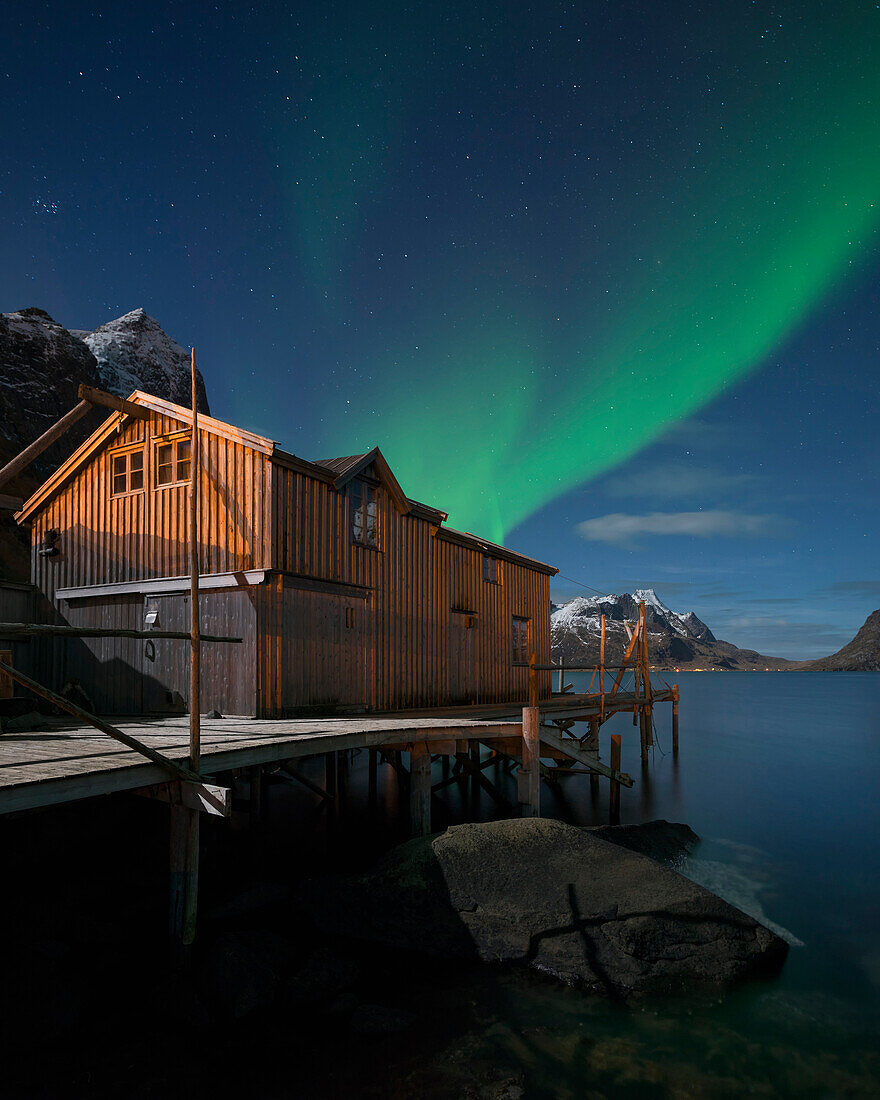 Northern Lights - Aurora Borealis shine in sky over abandoned Rorbu cabin, Valen, near Reine, Moskenes??y, Lofoten Islands, Norway