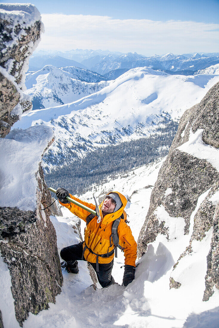 A mountaineer uses his ice axe to reach a hand-hold in the Coquihalla Recreation Area of British Columbia, Canada.