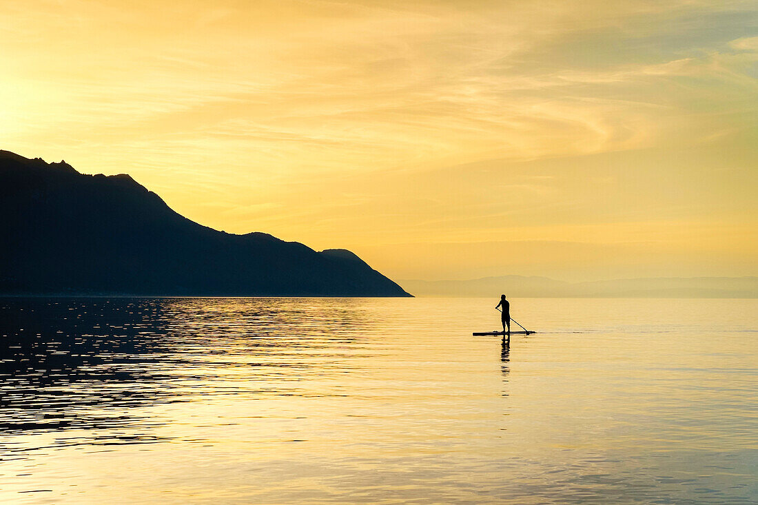 Man on stand up paddle board on Lake Geneva.