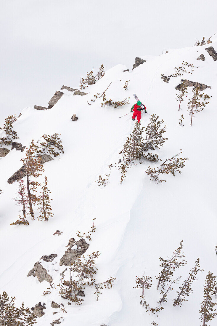 A male backcountry skier boot packs up a steep ridge to ski a line in the Beehive Basin near Big Sky, Montana.