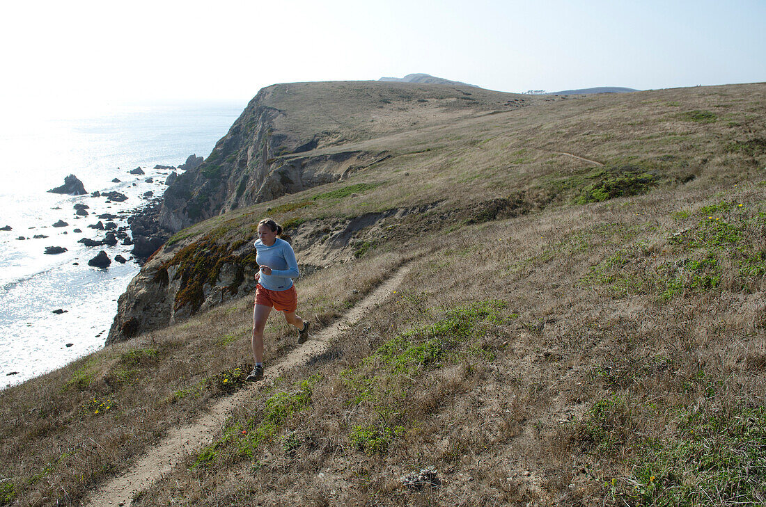 A woman enjoys the trial with a view at Point Reyes National Seashore, California.