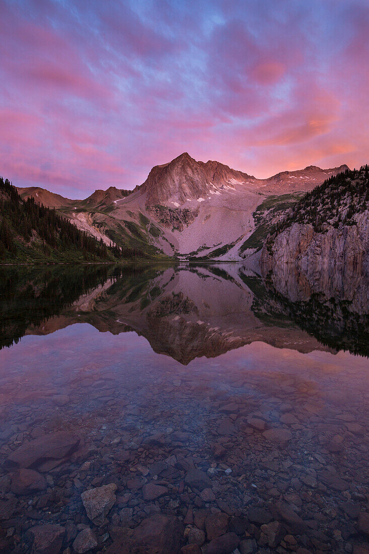 Snowmass peak reflected in Snowmass Lake at sunrise along Colorado's popular four pass loop trail.