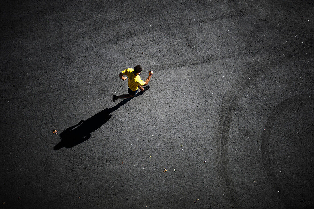 Young man running on the asphalt of the city in Barcelona, Spain.