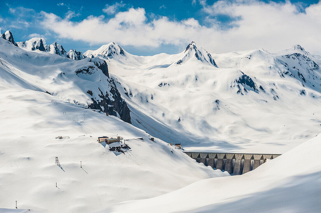 Dam for hydroelectric power production with snow-capped mountains in the background. Ossola, Italy.