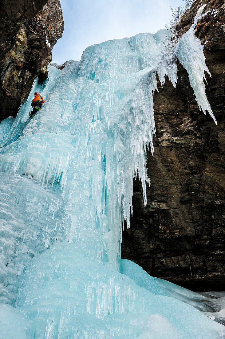 Man lead climbing an ice fall in Simplon Pass, Valais, Switzerland.