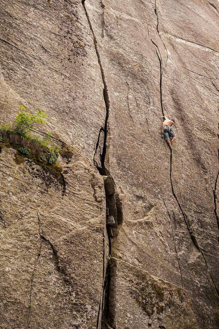 Italian climber trad climbing a crack route in Esigo, Ossola, Italy. Ossola is one of the main destination in Europe for crack climbing.
