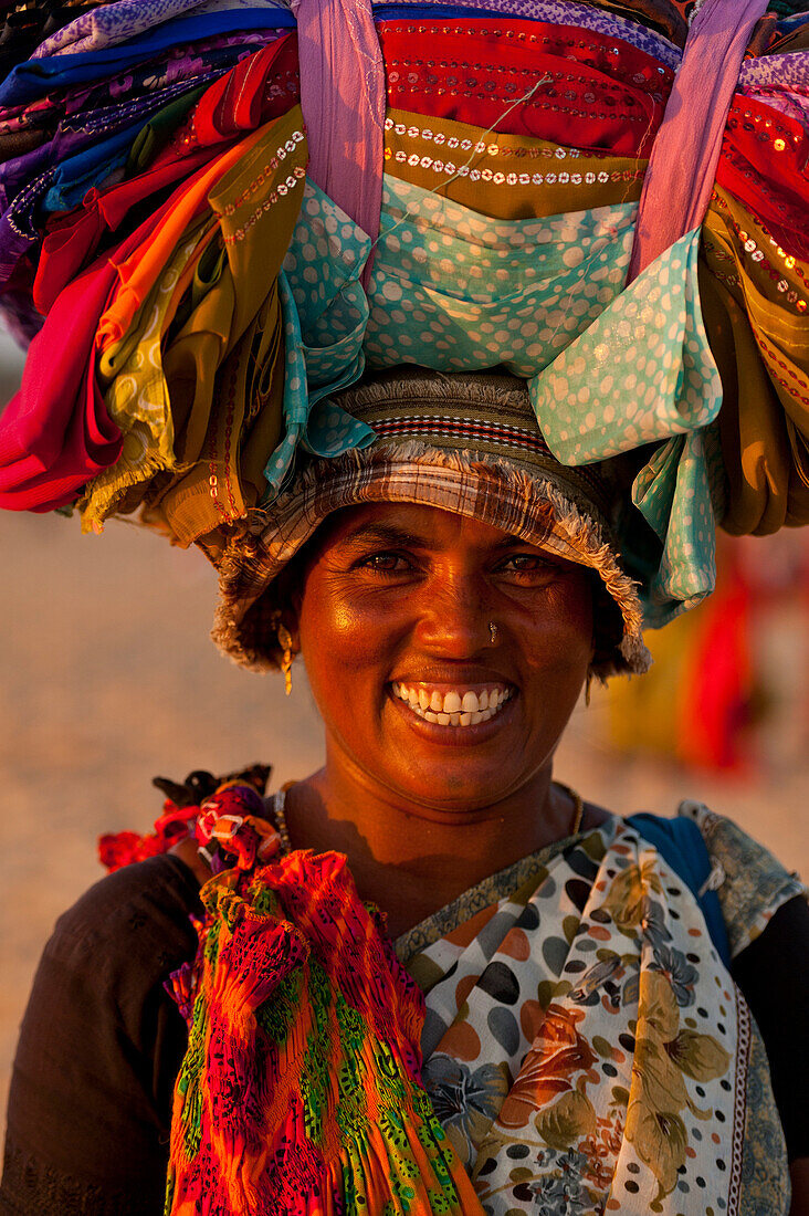 Lady Selling Indian Cloth On The Beach At Dusk, Candolim, Goa, India.