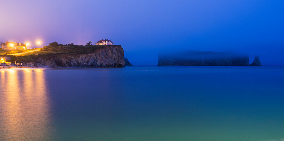 'Perce Rock and the town of Perce on the Gaspe Peninsula at nighttime; Perce, Quebec, Canada'