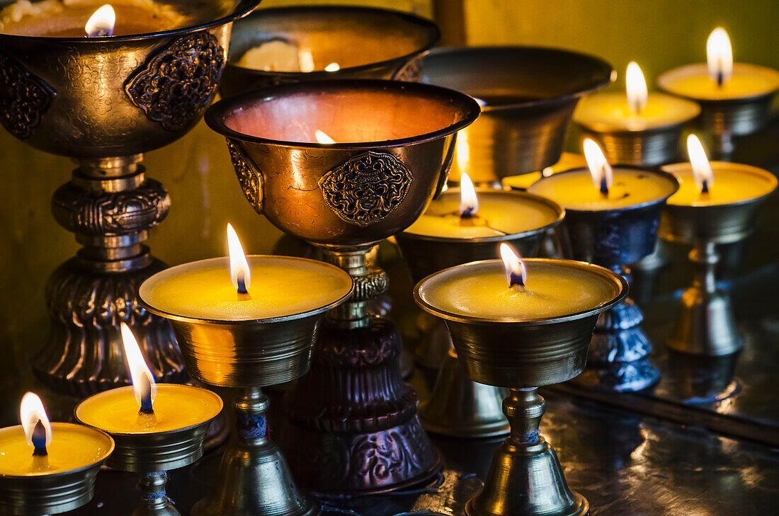 'Close up view of candles and lamps at Buddhist temple, Longwu monastery; Tibet, China'