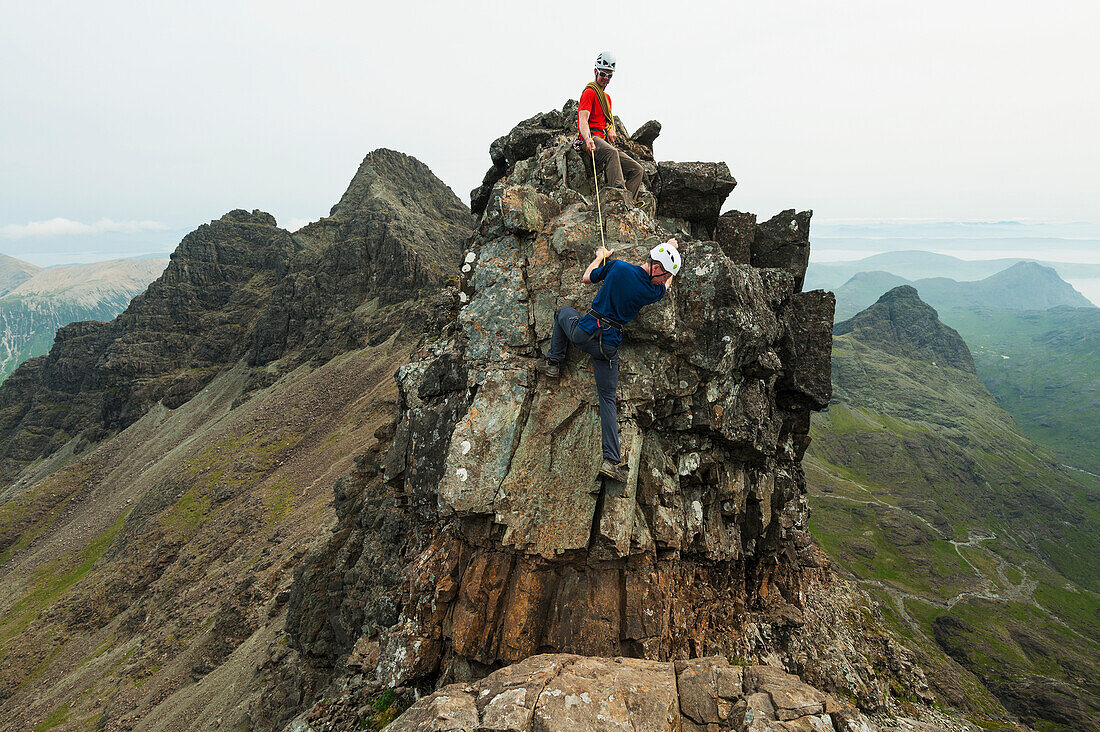 'Climber with rope on descending part of the ridge below Bruach na Frithe in the Black Cuillin; Isle of Skye, Scotland'