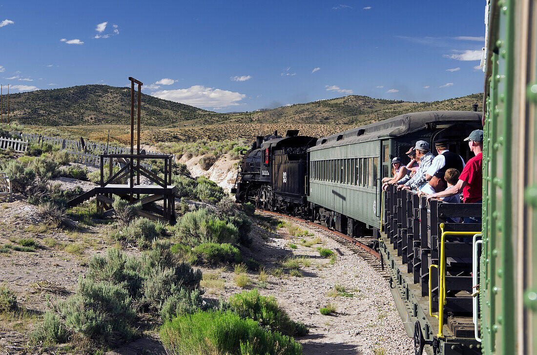 'Nevada Northern Railway train takes passengers on flat car into the hills; Ely, Nevada, United States of America'