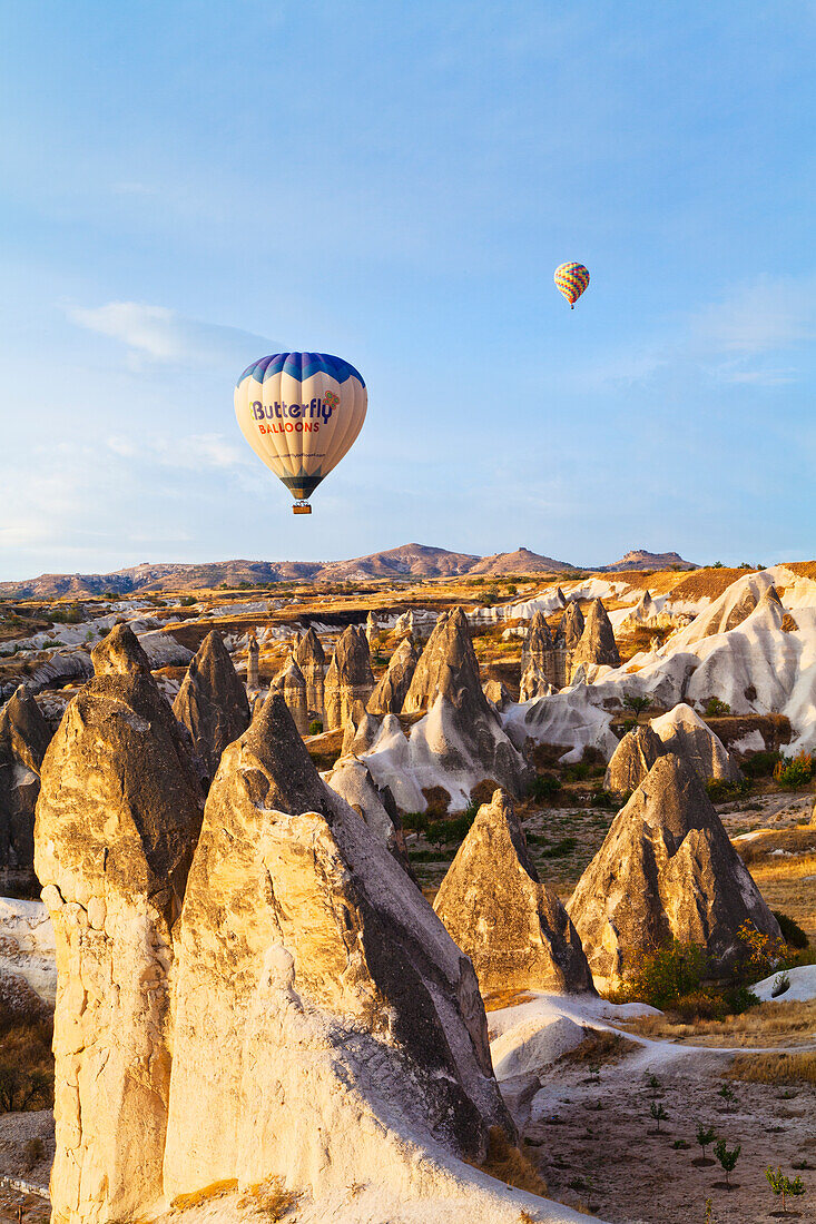 'Hot air balloons over the fairy chimneys and rugged landscape; Goreme, Cappadocia, Turkey'