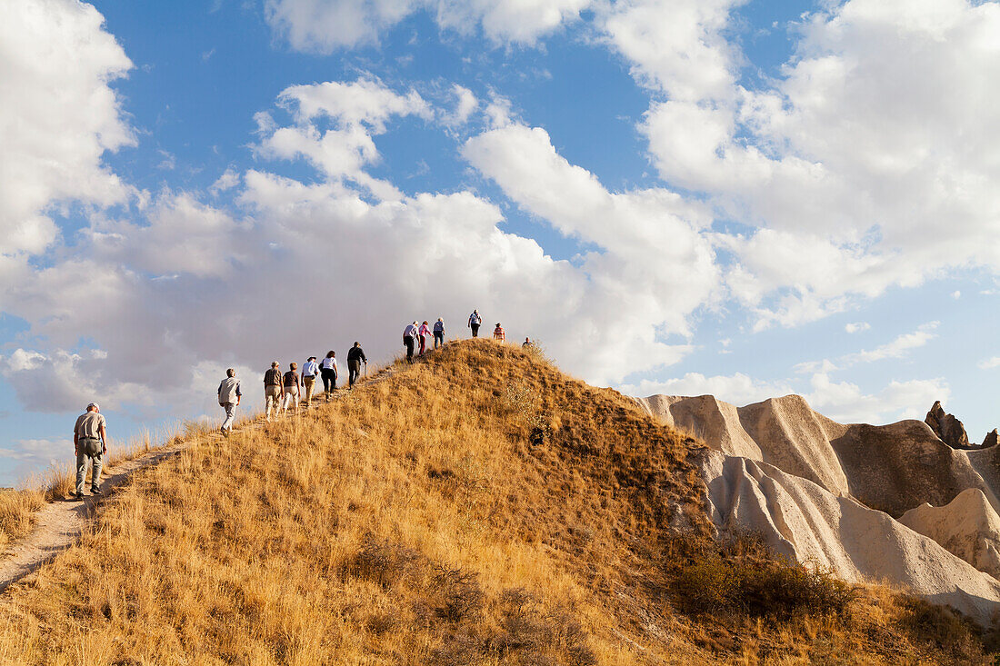 'A tour group hikes up a sloped trail in Rose Valley; Cappadocia, Turkey'
