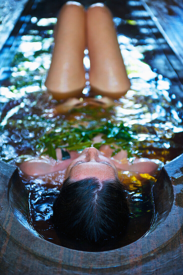 Eine Frau badet in einem Spa-Bad; Ulpotha, Embogama, Sri Lanka