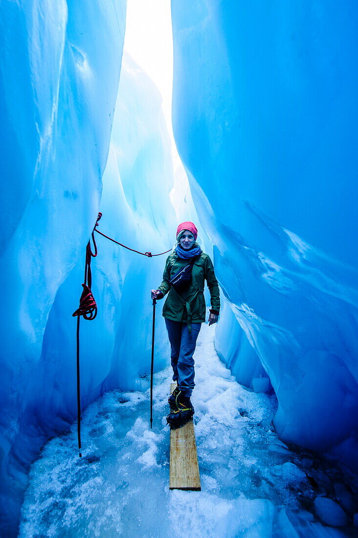 Woman standing in an ice cave, Fox Glacier, Westland Tai Poutini National Park, South Island, New Zealand, Pacific
